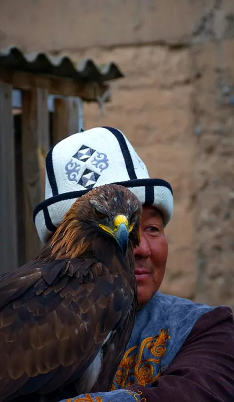 Adlerjäger mit weißem Kalpak und seinem Steinadler